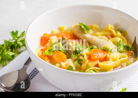 Huhn Nudelsuppe und Gemüse in einer weißen Schüssel auf einem weißen Hintergrund. Stockfoto