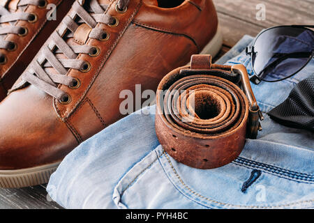 In der Nähe des braunen Leder Herren Stiefel, Gürtel, Sonnenbrillen und Blue Jeans Stockfoto