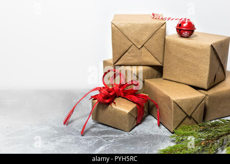 Kleine handgearbeitete Geschenkboxen mit roter Schleife, Christmas Ornament und Zweige mit leeren Raum für Text, Weihnachten und Neujahr Urlaub Konzept Stockfoto