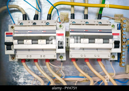 Zwei elektrische Drähte angeschlossen trozfaznyh Schalter auf Metall Hintergrund. Stockfoto