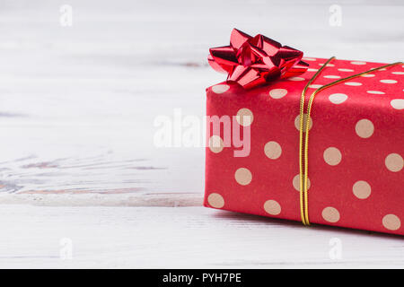 Polka Dot Weihnachtsgeschenk. Geschenk verpackt in rote gepunktete Papier und mit goldband gebunden. Urlaub Grußkarte. Stockfoto