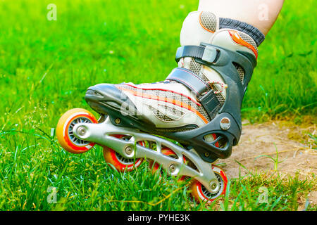 Detailansicht Inline Skates in das grüne Gras. In-line Skating Stockfoto