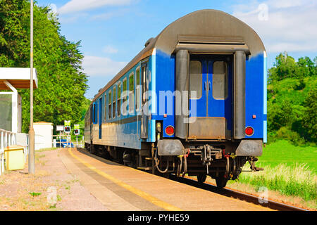 Blaue Bahn Wagen wartet an der Plattform für die Fahrgäste. Schienenverkehr in der Tschechischen Republik. Leere Plattformen auf regionaler Station. Einen sonnigen Tag auf. Stockfoto