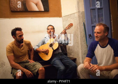 Zenon Melchor Getränke mezcal während Gitarre spielen in der Mezcal bar Los Amantes in der Mitte der Stadt von Oaxaca, Mexiko, 6. Oktober 2015. Stockfoto