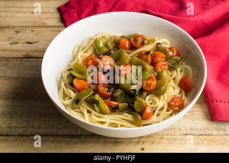 Vegan Pasta - Tomaten, grüner Pfeffer und Basilikum auf Spaghetti Nahaufnahme Stockfoto