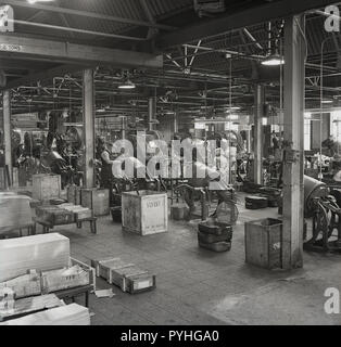 1950er Jahre, historische, männlich und fenale Arbeiter an der immer bereit ist, seiner Fabrik in Forest Road, Walthamstow, London die Überwachung der Maschinen produzieren Teile - trockenen Zellen - für Radio Batterien und Taschenlampen. Die Briten immer bereit, elektrische Firma (GEREK) war eine der größten britischen Unternehmen des EFR und die in den frühen 60er Jahren hatte 28 factorires in Großbritannien, ein Sprung von seinen Start in bueinss als ein einziger Shop in Charing Cross Road. Stockfoto