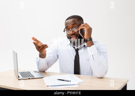 Afrikaner - Office Manager im Büro sitzt mit Laptop, Lesen wichtiger Dokumente mit verwirrten Ausdruck und halten Kopf mit seiner Hand Stockfoto