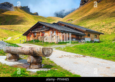 Alpine Holz- Bauernhaus mit spektakulären Weide in nebligen Berge in der Nähe von Grindelwald, Berner Oberland, Schweiz, Europa Stockfoto