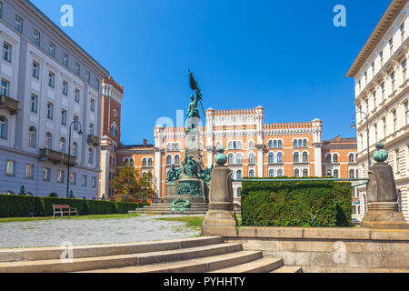 Denkmal der Deutschmeister Rossauer Kaserne auf einem Platz der Stadt unter weißen und orangefarbenen Backsteinbauten in Wien, Österreich. Stockfoto