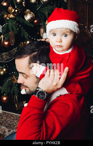 Schönen Baby auf Papa's Schulter zu Weihnachten. Stockfoto