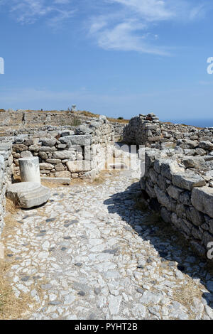 Enge gepflasterte Straße schlängelt sich durch das Wohngebiet im westlichen Teil der antiken Stadt Thera, Santorini, Griechenland. Aus dem Stockfoto