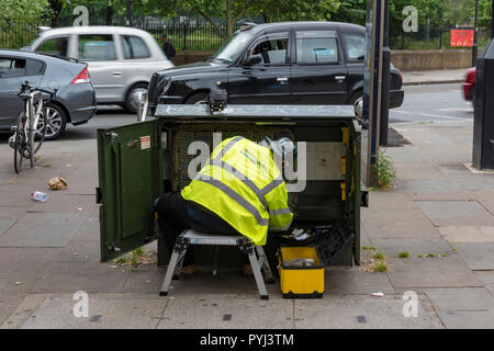 Ein Telekom Mitarbeiter die Reparatur von Leitungen und Kabel in einem Schrank oder in einem Schrank an der Seite der Straße im Zentrum von London. Stockfoto