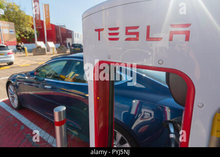 Ein Tesla Auto mit einem Der upercharger' Parkplatz Stockfoto