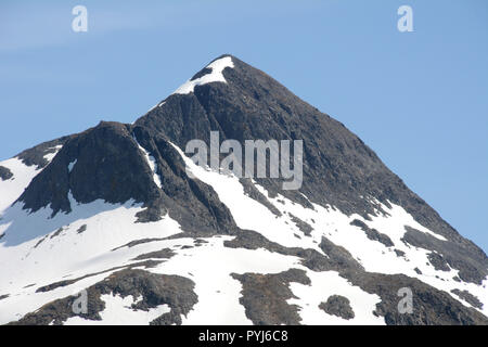 Ein teilweise schneebedeckten Rocky Mountain Peak auf der Insel Unalaska, Aleuten, Alaska, United States. Stockfoto