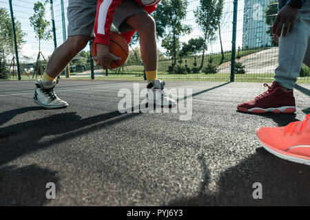 Nahaufnahme eines orange Kugel in Spieler Hände Stockfoto