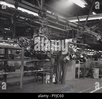 1970 s, historischen, einen männlichen Auto worker Gebäude PKW-Motoren an der Vauxhall Auto Anlage, Luton, England, UK. Dieser Ära sah die Anfänge der massive Rückgang in der britischen Automobilindustrie aufgrund einer Vielzahl von Gründen, einschließlich unattraktive Modelle, Arbeitskämpfe, restriktiven Praktiken, Qualität, inefficencies und alte Technik und Ausstattung. Stockfoto