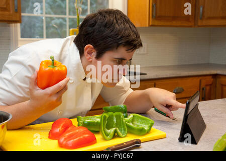 In der Nähe der Person in der Küche an Ihren Tablet suchen Hilfe bei einem Kochrezept zu erhalten Stockfoto