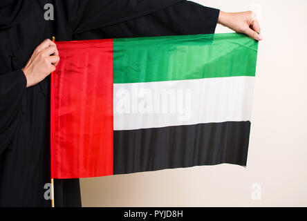 Frau in Abaya holding Vereinigte Arabische Emirate Flagge closeup Stockfoto