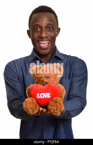 Junge glücklich afrikanischer Mann lächelnd und Teddybär mit Herz Stockfoto