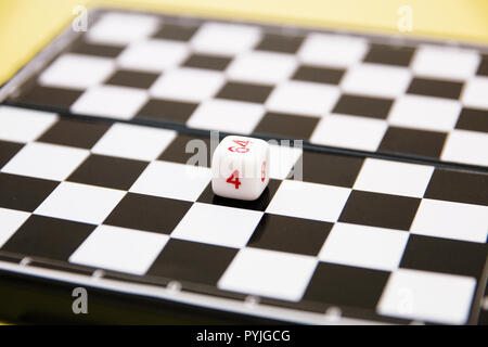 Würfel mit Zahlen auf dem Hintergrund des Schachbretts Stockfoto