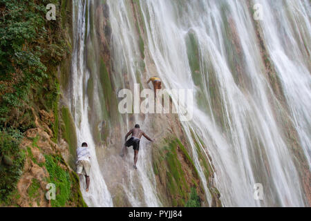 Dominikanische Republik, Puerto Plata, 24. NOVEMBER 2011: Junge Kerle klettern die Leisten von einer Klippe an der Wasserfall Stockfoto