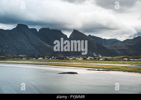 Eine typische Lofoten Beach view Frames das Meer bei Ramberg Lofoten. Szene an einem schönen Tag mit blauem Himmel und einige Wolken mit Gras im Vordergrund. L Stockfoto