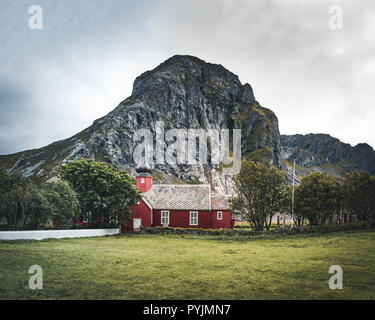 Flakstad Kirche mit Bergen im Hintergrund, exquisite XVIII Jahrhundert barockes Meisterwerk in der Arktis, Flakstadoy, Lofoten, nördlich des Stockfoto