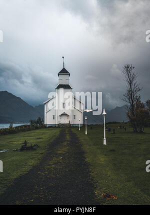 Lange Belichtung der weißen Kirche von Gimsoy mit Felsen und den Atlantischen Ozean. Foto auf der Insel Gimsoy, Lofoten Norwegen übernommen. Foto in Norwegen übernommen. Stockfoto