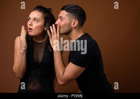 Junges Paar zusammen und in der Liebe gegen braunen Hintergrund Stockfoto