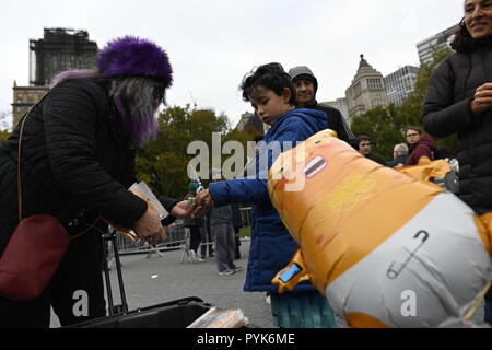 New York, USA 28. Oktober 2018. Eine junge Person kauft ein Miniatur-Ballon, Präsident Trumpf als Baby in Windeln bei einer Rallye von Demonstranten fordern Amtsenthebung ist Trumpf. Eine 20 Fuß hohe Version der Ballon war die Hauptattraktion während der Rallye im New Yorker Battery Park. Die Demonstranten haben ähnliche Ballons in anderen anti-Trumpf-Proteste in den USA und Großbritannien die Rallye und März von einer Gruppe von Menschen, die beschuldigt die Präsidenten der Hohen begehen Verbrechen und Vergehen genannt organisiert wurde. Credit: Joseph Reid/Alamy leben Nachrichten Stockfoto