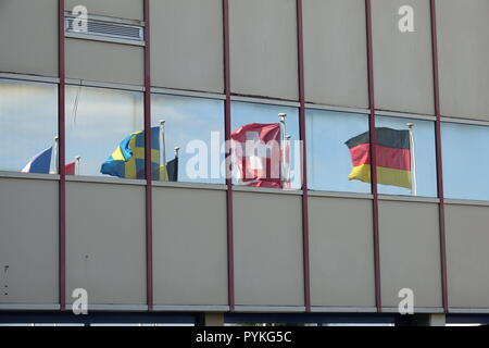 Korou, Frankreich. Okt, 2018 19. Die Fahnen von mehreren europäischen Ländern werden im Fenster vor einem Gebäude auf dem Weltraumbahnhof Kourou in Französisch-Guayana wider. Diese sind die Flaggen der Mitgliedstaaten der Europäischen Weltraumorganisation ESA. Credit: Janne Kieselbach/dpa/Alamy leben Nachrichten Stockfoto