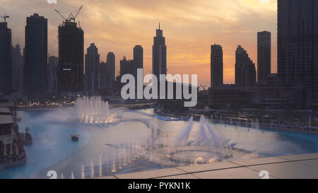 Dubai Fountain ist der weltweit größte choreographiert Brunnen System auf Sonnenuntergang Hintergrund Stockfoto