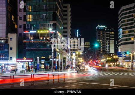 Leichte Wanderwege mit dem Auto Scheinwerfer und Rückleuchten in einer Stadt Szene in Haeundae, Busan in der Nacht verlassen. Stockfoto