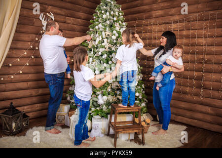 Eine große Familie ist schmücken einen Weihnachtsbaum. Vorbereitung für das Neue Jahr. Frohe Weihnachten. Familienfeier. Große familie in der Sammlung Stockfoto