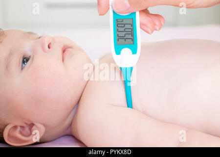 Baby krank mit Elektrische Thermometer. Kind Fieber krank. Kid fangen kalt mit der Temperatur. Kind krank im Bett mit Fieber messen Temperatur wi Stockfoto