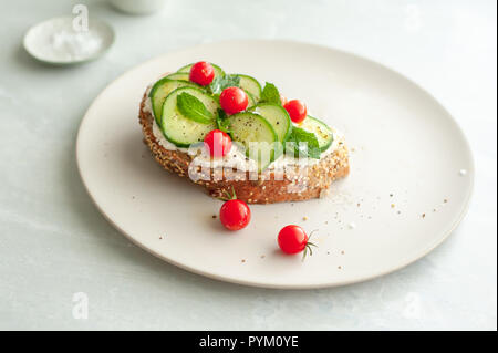 Mediterranem Einfluss auf Bruschetta mit Frischkäse, Minze, Gurke und Tomaten. Stockfoto