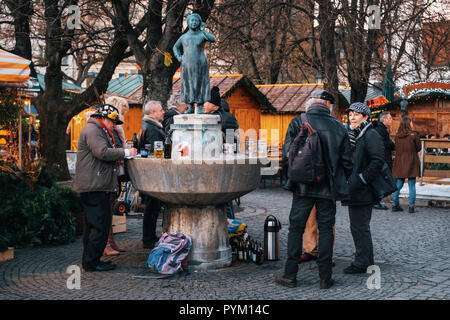 München, Deutschland - Dezember 7, 2017: Lokale Leute genießen Bier Getränke und Essen an Speise Markt Viktualienmarkt in der Nähe der Statue Liesl Karlstadt in M Stockfoto