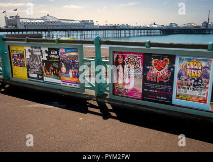 Brighton's Palace Pier von der viktorianischen Promenade am Brighton Beach aus gesehen. Theaterwerbung am Handgeländerzaun Stockfoto