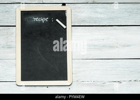 Tafel mit dem Wort 'Rezept' auf Weiß, rustikalen Holzmöbeln Wand Stockfoto