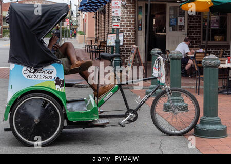 Der Fahrer einer Rikscha Zyklus oder fahrradrikscha Taxi eine Pause an einer Straßenecke in Savannah Georgia USA Stockfoto