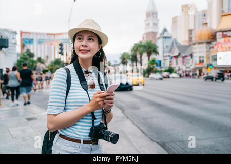 Weibliche Reisende suchen die Lage des nächsten Spot per Handy in Las Vegas. Reisen Fotografen mit taxi App auf der Straße. lady Backpacker sel Stockfoto