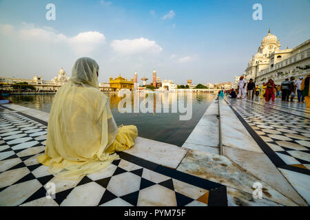 Ein Sikh Anhänger ist Sitzen und Meditieren am heiligen Pool der Harmandir Sahib, der Goldene Tempel Stockfoto