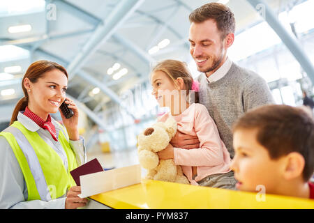 Familie vor der Abreise in den Urlaub am Flughafen in Zähler bei der Passkontrolle prüfen Stockfoto