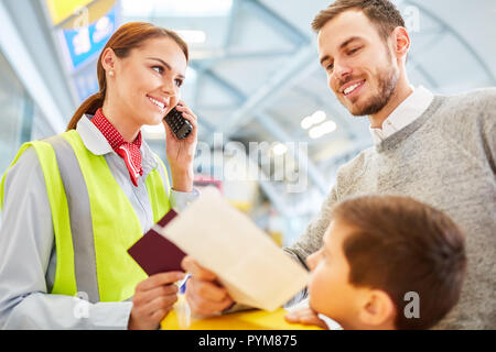 Service Sekretärin am Check-in-Schalter prüft Dokumente und macht einen Anruf Stockfoto