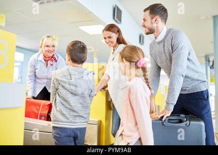 Familie und Kinder in den Flughafen Terminal am Check-in-Schalter auf dem Weg in den Urlaub Stockfoto