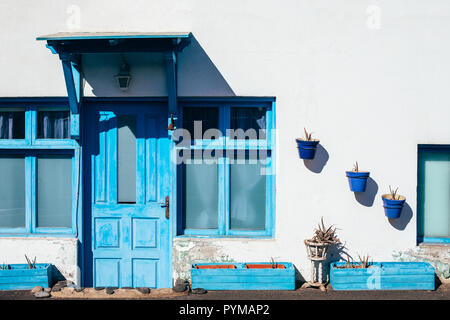 Traditionelles kanarisches Haus mit weißen Wänden, blauen Tür und Fenster auf Lanzarote Stockfoto