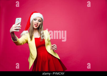 Hübsches Mädchen in rot Santa Hut und Kleid unter selfie über Zelle ov Stockfoto