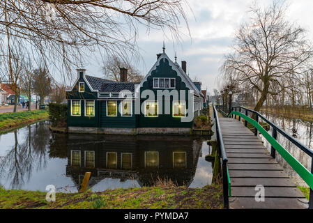 Schöne und typisch Holländischen Holzhäuser Architektur gespiegelt auf dem ruhigen Kanal von Zaanse Schans nördlich von Amsterdam, Niederlande Stockfoto