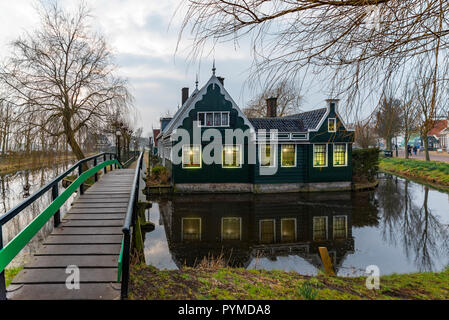 Schöne und typisch Holländischen Holzhäuser Architektur gespiegelt auf dem ruhigen Kanal von Zaanse Schans nördlich von Amsterdam, Niederlande Stockfoto