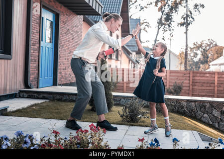 Junge gerne Vater High Five, um seine kleine süße Tochter zu geben Stockfoto